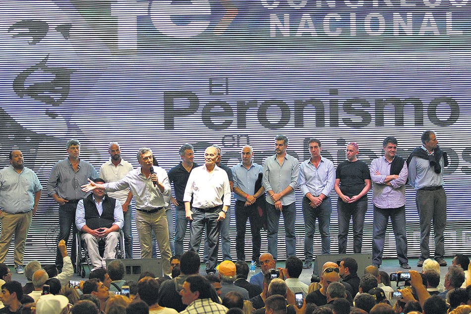 El Presidente y su gabinete detrás del cartel de “El Peronismo en Cambiemos” en el acto del club Ferro.
