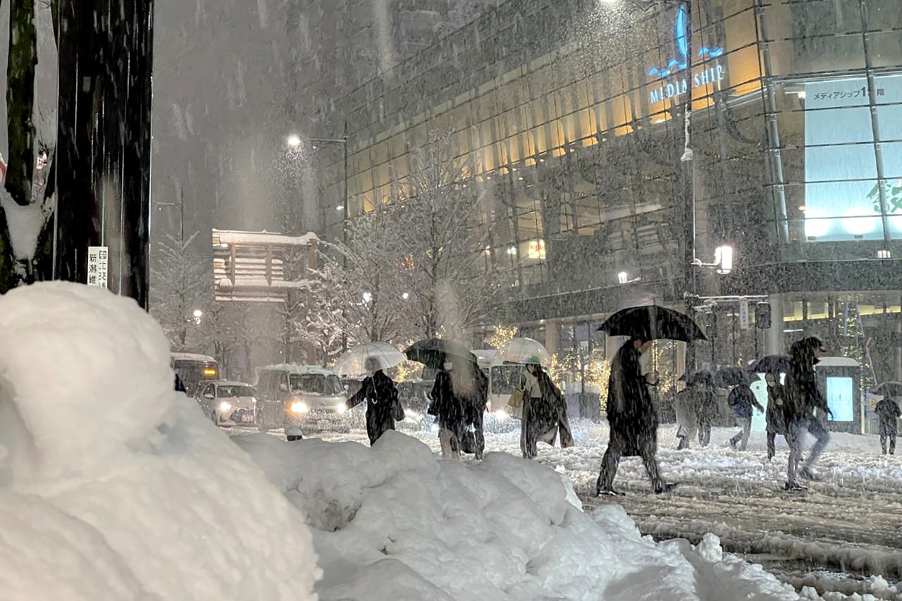 La gente cruza una calle cubierta de nieve en Niigata, en la costa oeste de Japón.