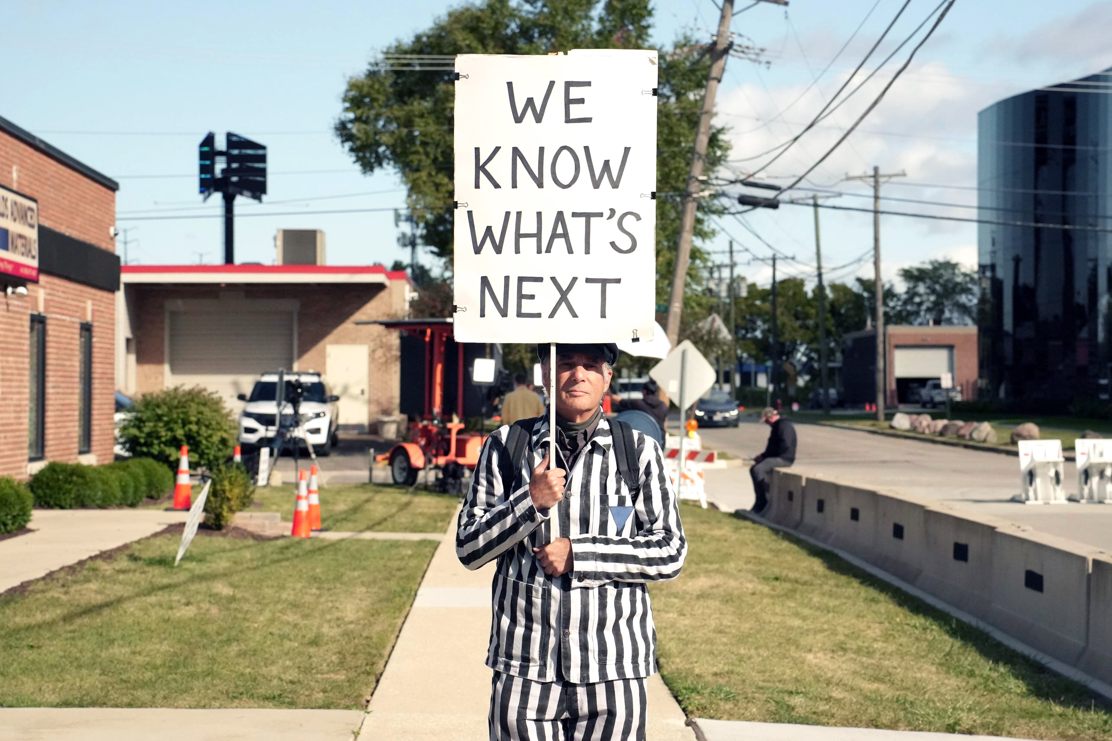 Un hombre sostiene un cartel afuera del centro de detención de migrantes que dice: "Sabemos que sigue".