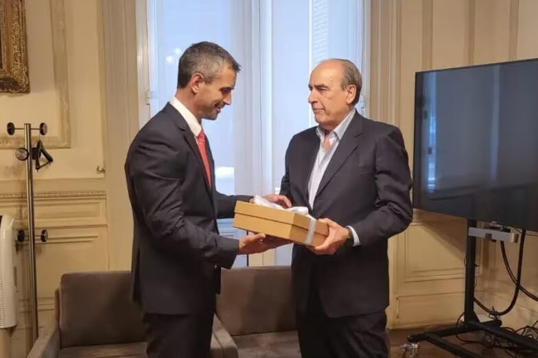 El ministro del Interior, Guillermo Francos (der.), le entrega al titular de la Cámara de Diputados, Martín Menem, el paquete con más de 300 hojas denominado "Ley de Bases y Puntos de Partida para la Libertad de los Argentinos".