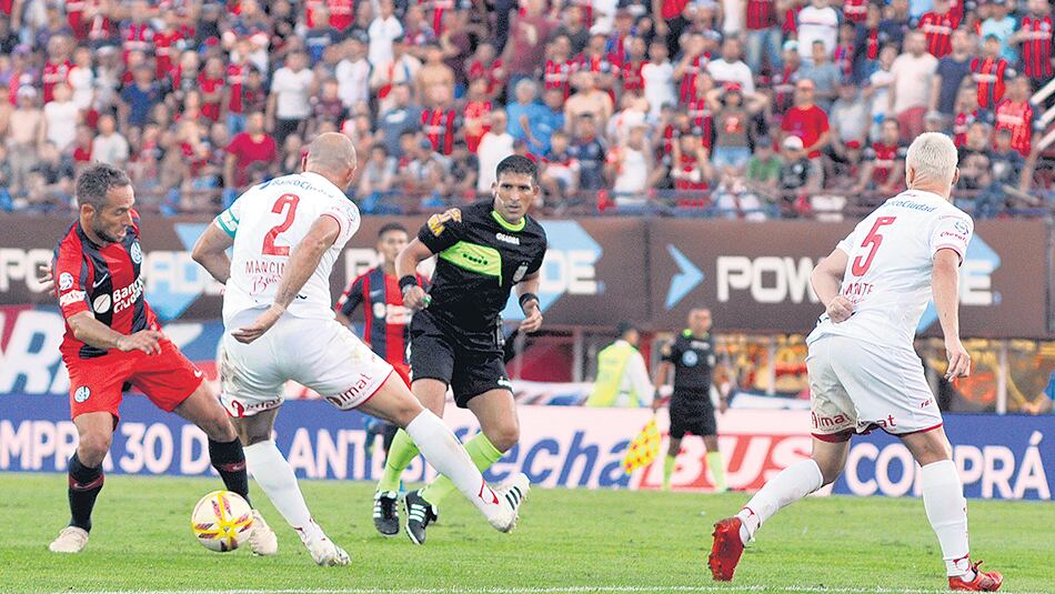 Belluschi trata de superar la marca de Mancinelli, mientras Damonte sigue de cerca la jugada.