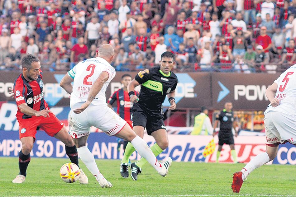 Belluschi trata de superar la marca de Mancinelli, mientras Damonte sigue de cerca la jugada.