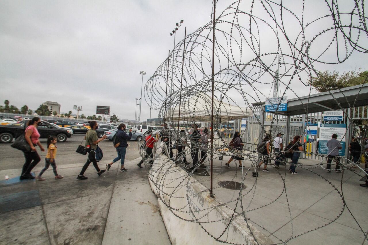 Personas hacen fila para ingresar a  Estados Unidos en el cruce fronterizo Tijuana-San Ysidro.