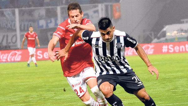 Juan Ramírez aguanta la pelota frente a la presión de Nicolás Silva.