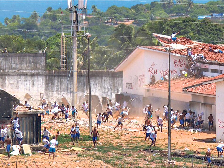 Prisioneros se dispersan para eludir las balas de goma de la policía antidisturbios en el penal de Alcaçuz, cerca de Natal.
