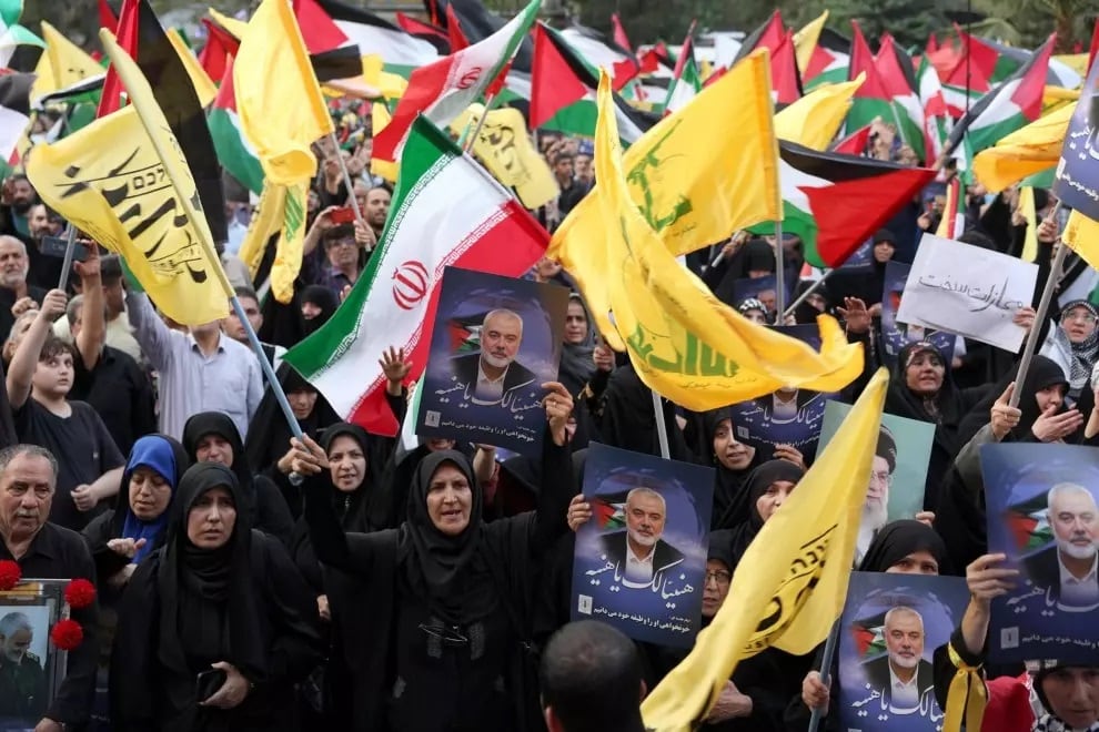 Iraníes sostienen una imagen del fallecido líder de Hamas, Ismail Haniyeh, y banderas palestinas y de Hezbollah durante una protesta en la Plaza de Palestina en Teherán, Irán, el 31 de julio de 2024.
