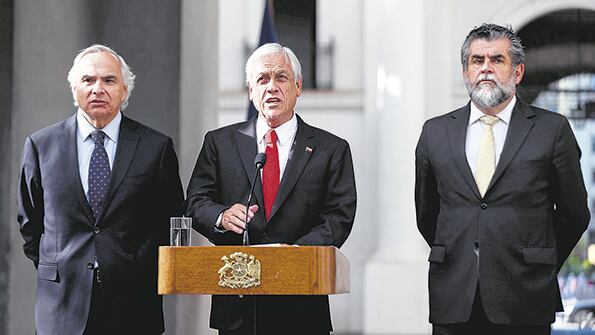 Flanqueado por el ministro y el secretario de Interior, Piñera anuncia la dimisión del jefe de Carabineros.