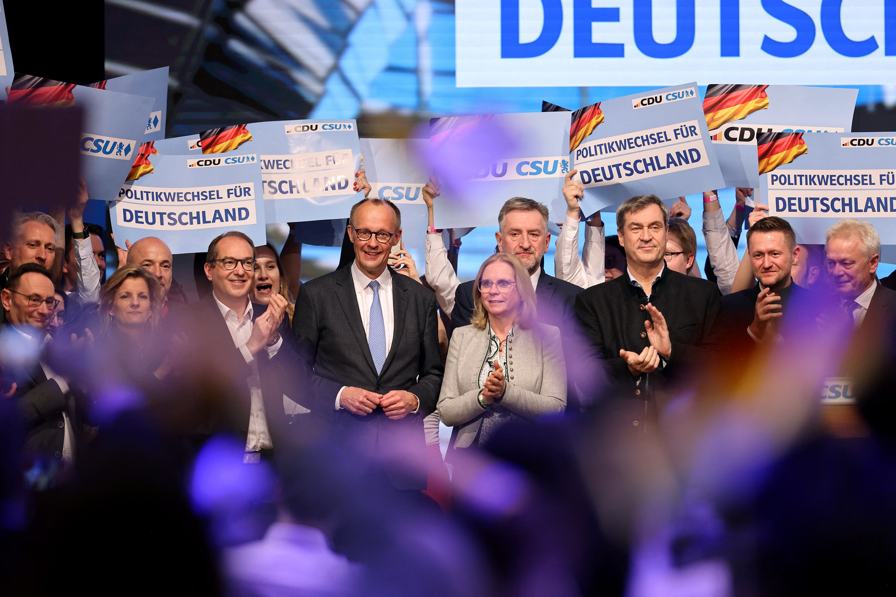 Merz (centro, izq.) sonríe durante el cierre de campaña en Munich.