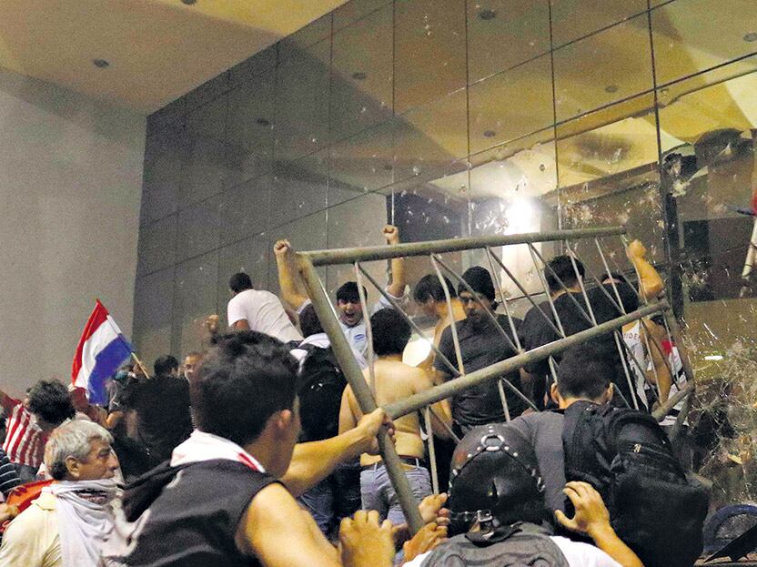 Unos centenares de manifestantes rompieron vallas y prendieron fuego al Congreso Nacional en Asunción.