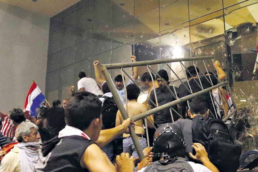 Unos centenares de manifestantes rompieron vallas y prendieron fuego al Congreso Nacional en Asunción.