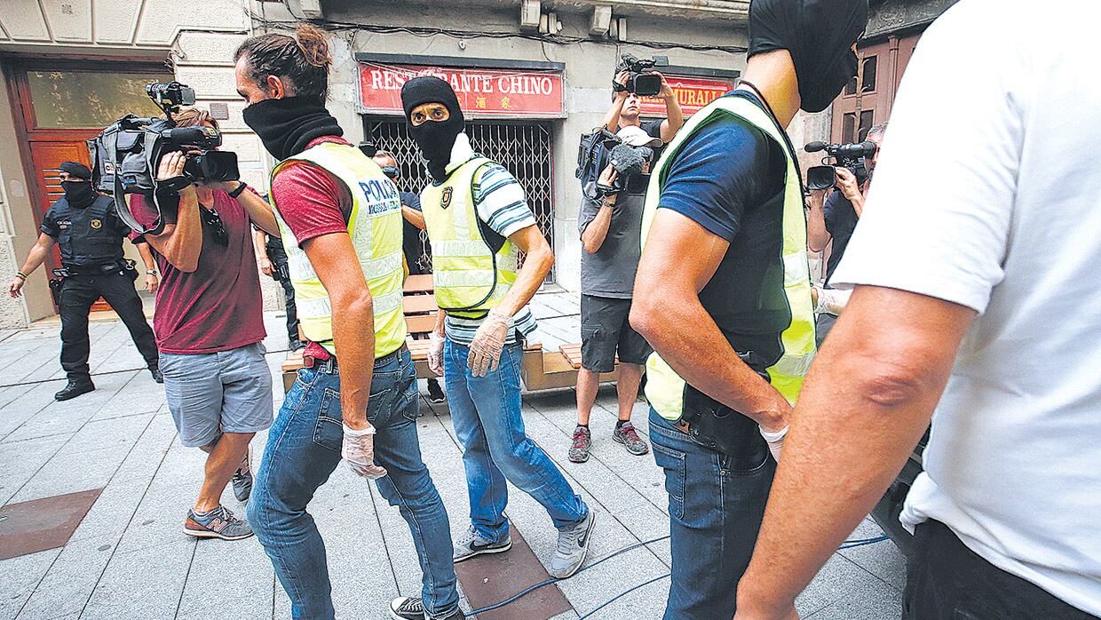 Policías catalanes salen de un edificio en Ripoll después de un allanamiento por los atentados del jueves.