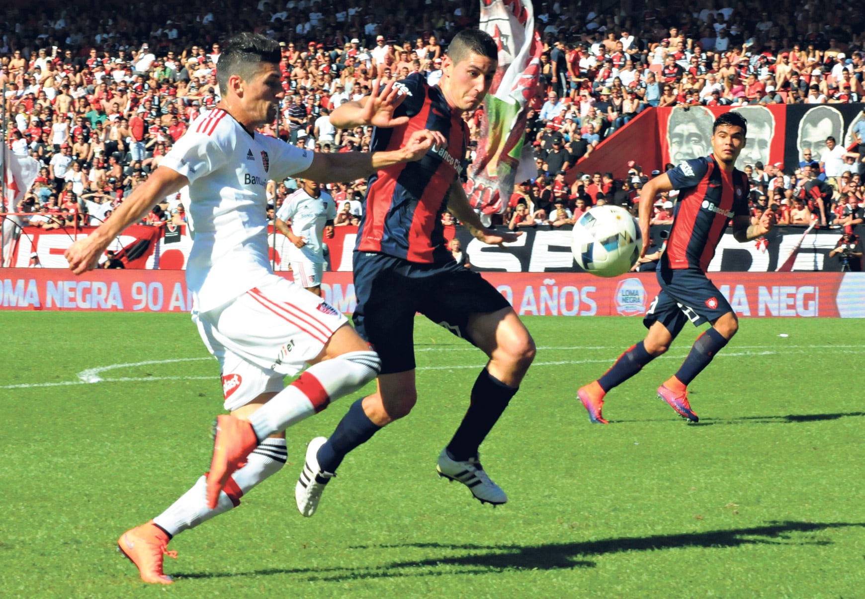 Amoroso y Merlini se enfrentan dentro del área de San Lorenzo en uno de los pasajes del primer tiempo del duelo jugado en Rosario.