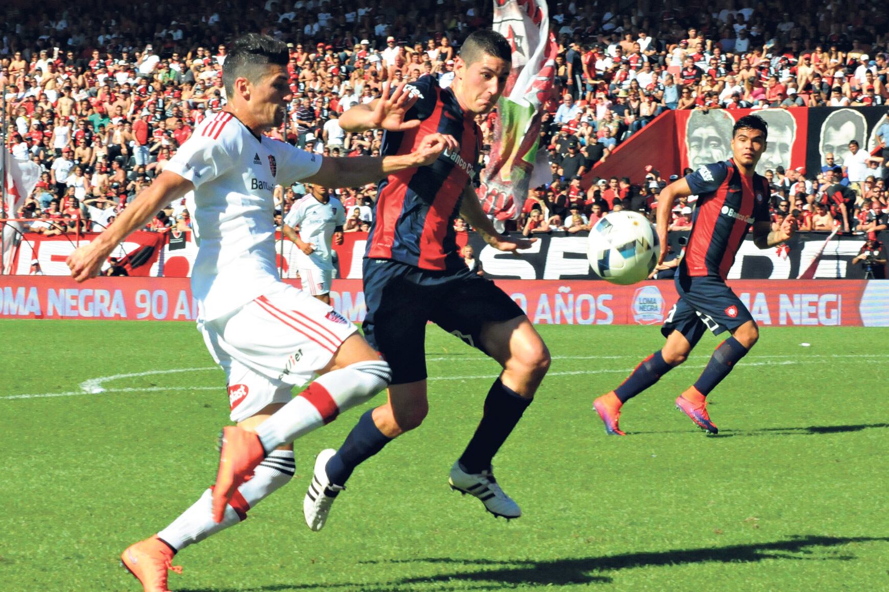 Amoroso y Merlini se enfrentan dentro del área de San Lorenzo en uno de los pasajes del primer tiempo del duelo jugado en Rosario.