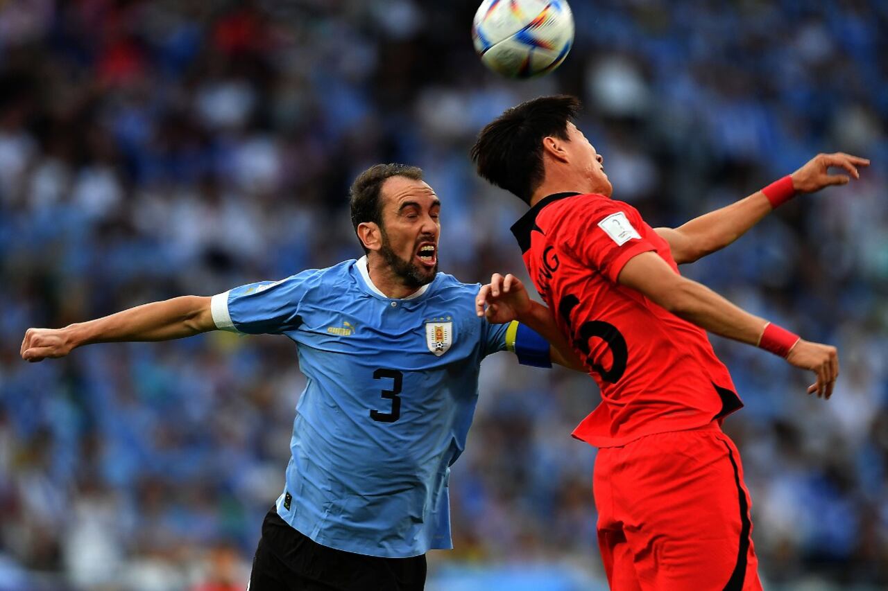 Diego Godín lucha por la pelota con un jugador coreano