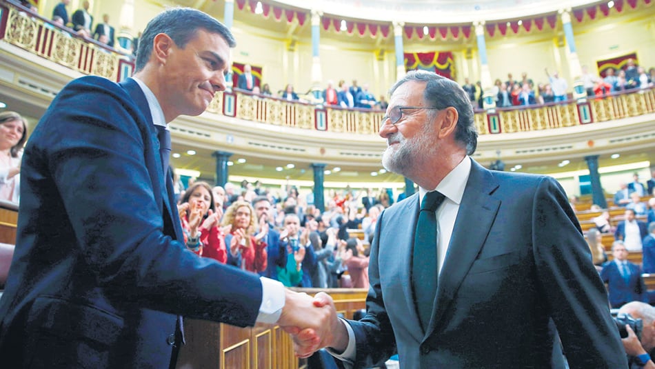 Pedro Sánchez recibe el saludo de su antecesor, Mariano Rajoy, instantes después de su investidura, ayer, en el Congreso español.