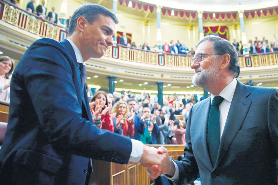 Pedro Sánchez recibe el saludo de su antecesor, Mariano Rajoy, instantes después de su investidura, ayer, en el Congreso español.