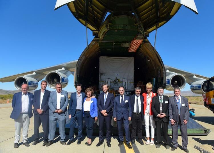 Los funcionarios junto al avión que lleva el satélite a Estados Unidos.