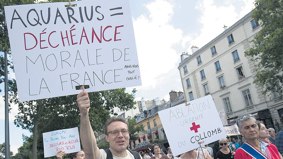 Un grupo de manifestantes expresa su solidaridad con los migrantes pasajeros del buque Aquarius en París.