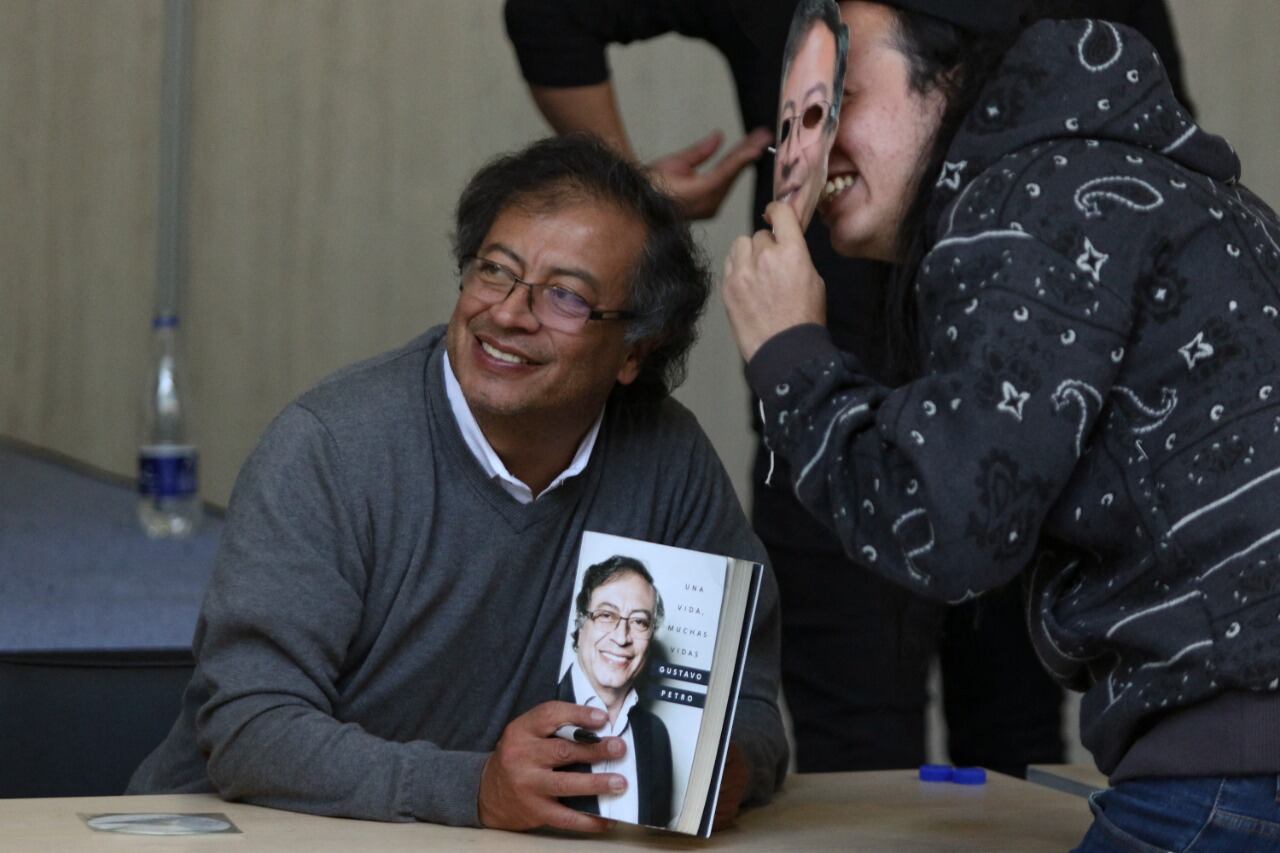 Gustavo Petro sonríe junto a un simpatizante en la Feria del Libro de Bogotá.