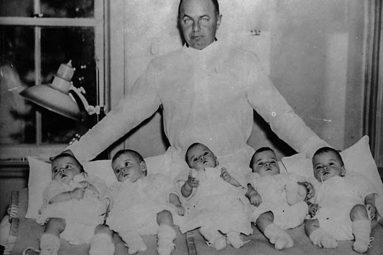 El gobernador de Ontario, Mitchell Hepburn, posa con las quintillizas. 