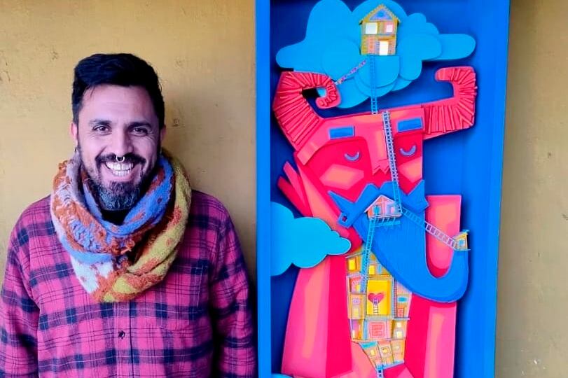 El artista plástico Lucas Guigón y junto a uno de los diablitos de su obra.