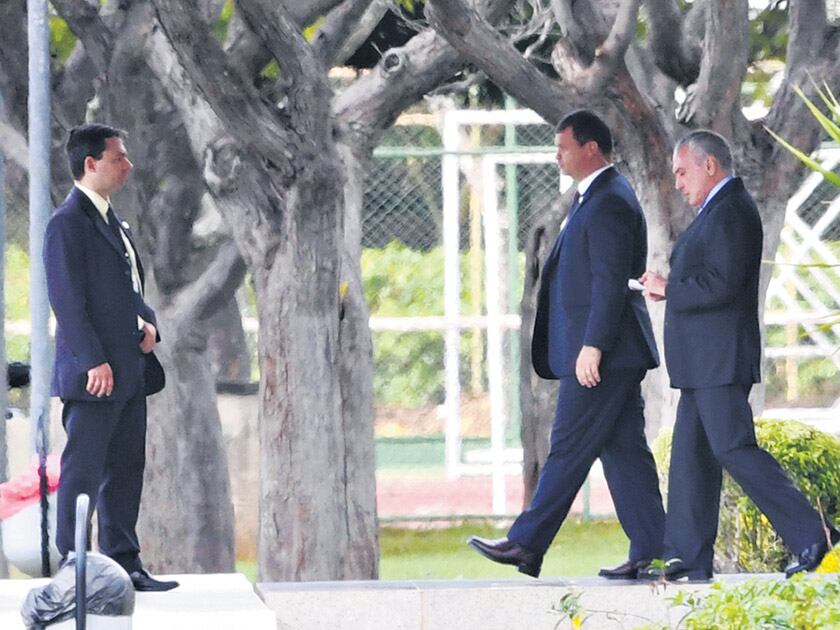 Temer (der.) sale de la residencia presidencial rumbo al palacio de gobierno en Brasilia.
