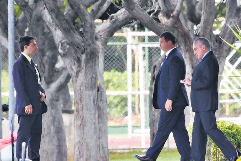 Temer (der.) sale de la residencia presidencial rumbo al palacio de gobierno en Brasilia.