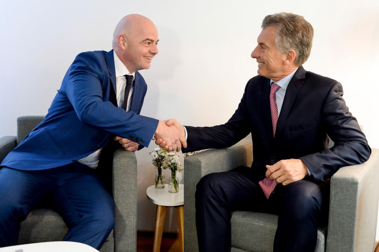 Infantino y Macri se dan un fuerte apretón de manos.