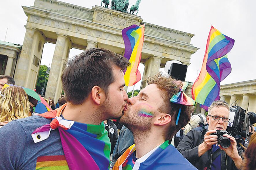 Dos hombre se besan frente a la Puerta de Brandenburgo en una marcha a favor de la ley igualitaria.