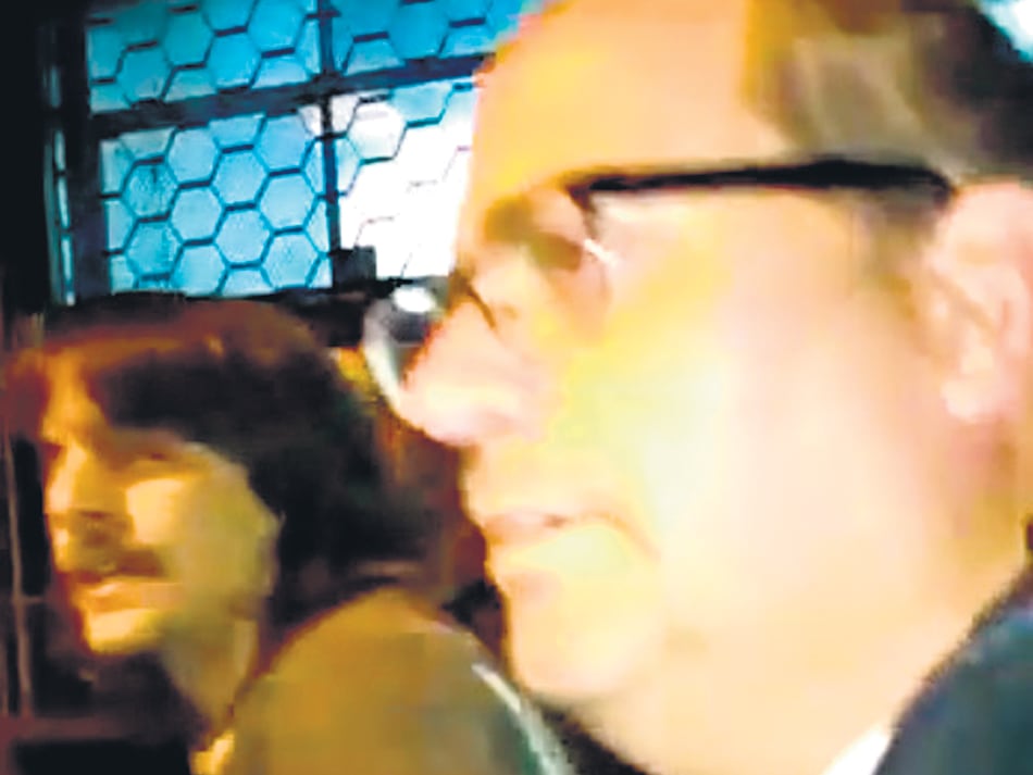 El docente, Juan Pablo Manente (izq.) y uno de los policías no identificados que lo detuvieron.