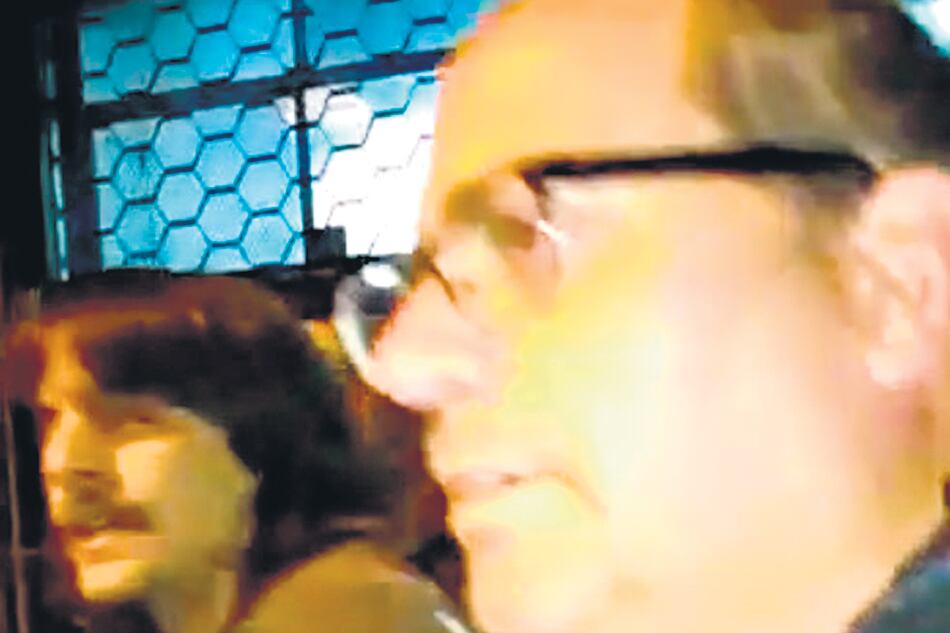 El docente, Juan Pablo Manente (izq.) y uno de los policías no identificados que lo detuvieron.