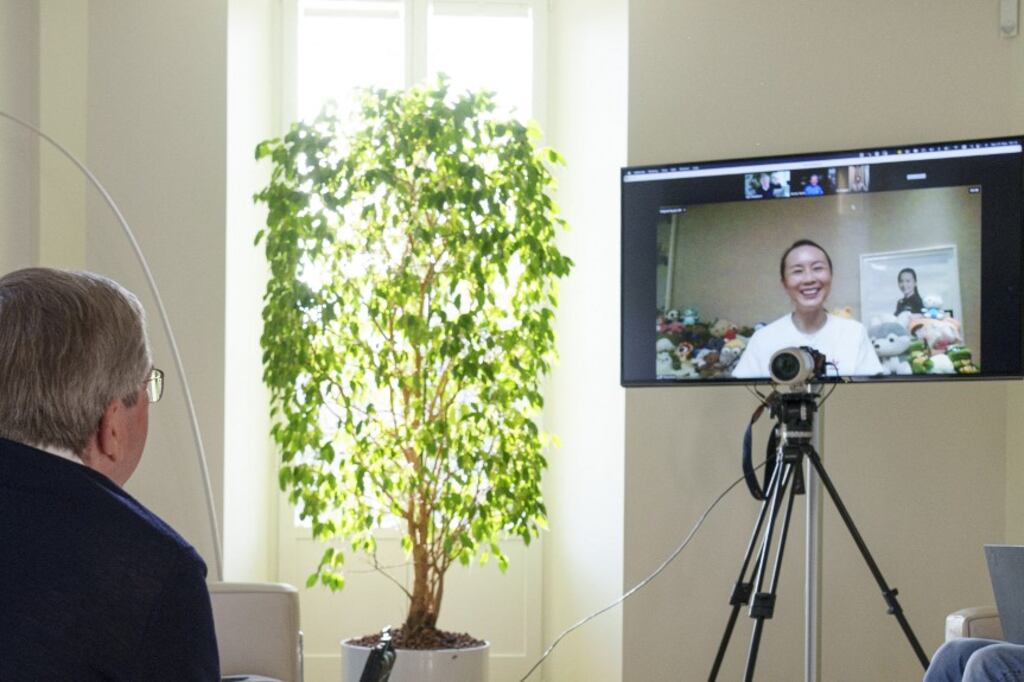 Peng Shuai en la pantalla, ante el alemán Thomas Bach, presidente del COI