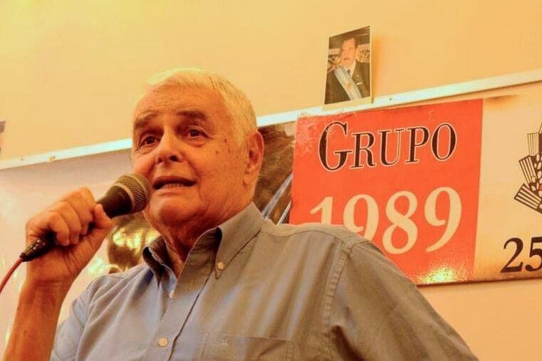 Bielicki habla detrás de una imagen de Raúl Alfonsín. 