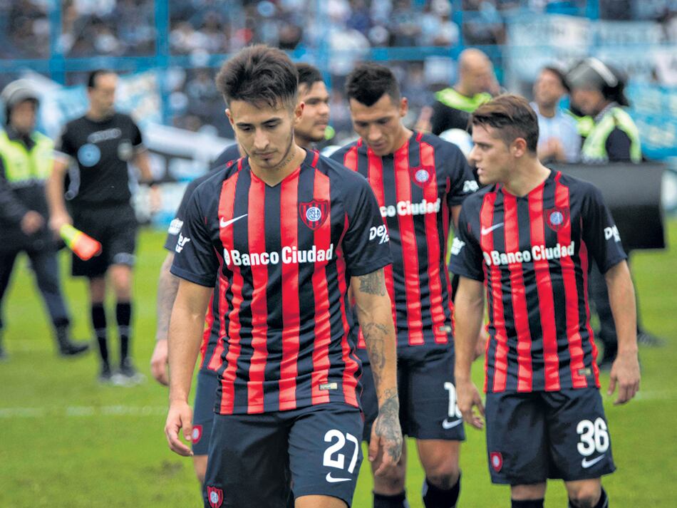Los jugadores de San Lorenzo se van de la cancha cabizbajos por la derrota.