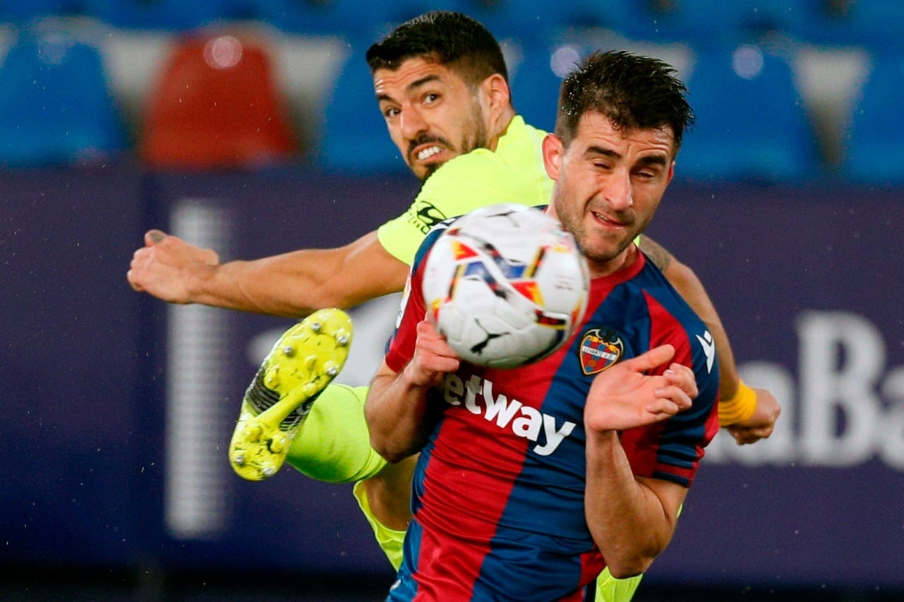 Suárez intenta rematar ante un rival.