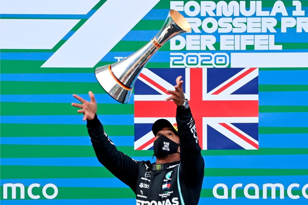 Hamilton festeja lanzando su trofeo en Alemania.