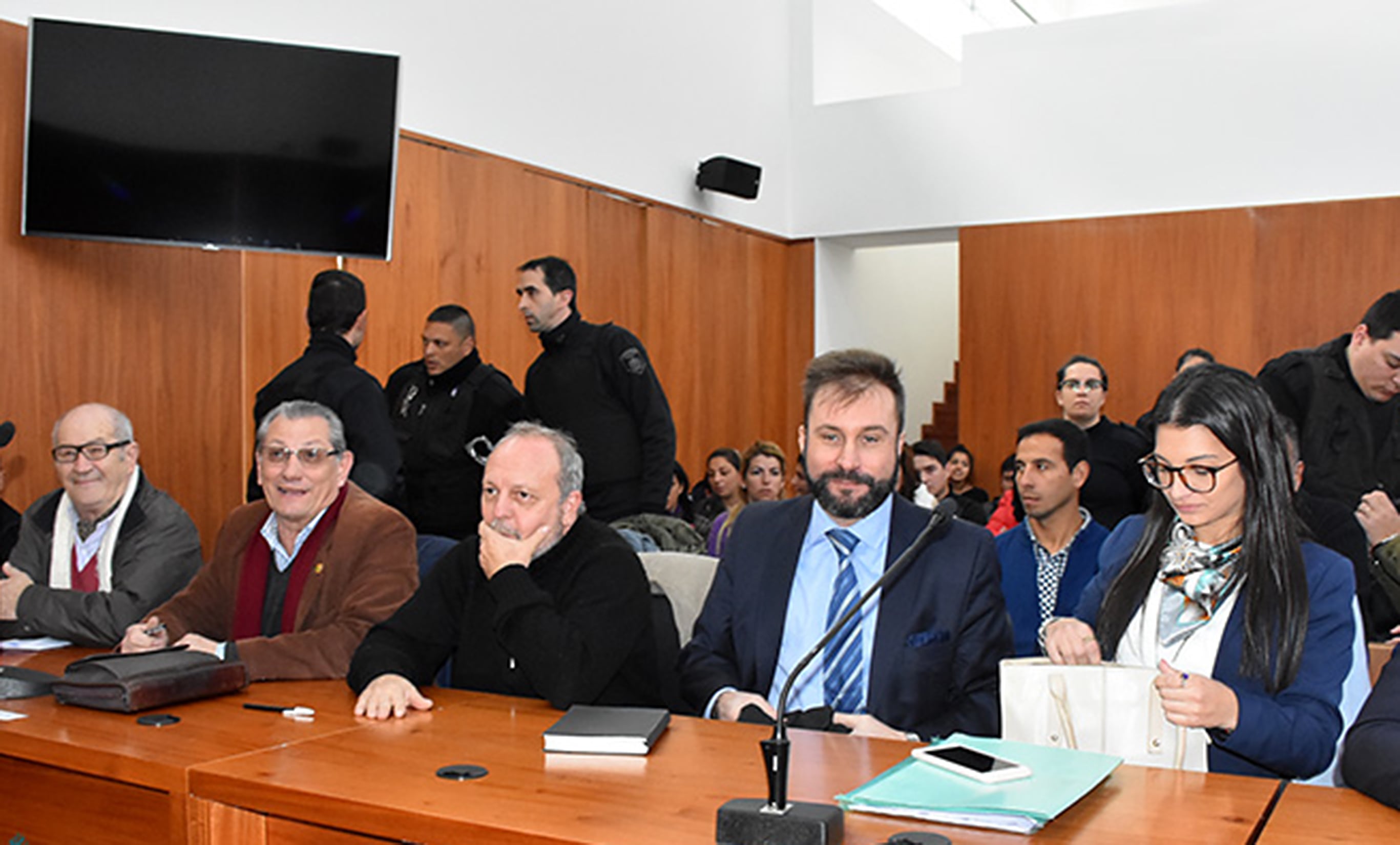 Un grupo de abogados defenseros de los policías escucha el dictamen de los magistrados.