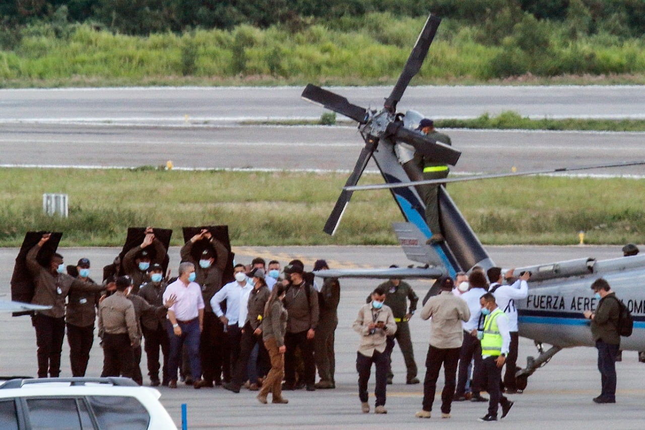 Rodeado de custodios Duque camina junto al helicóptero baleado.