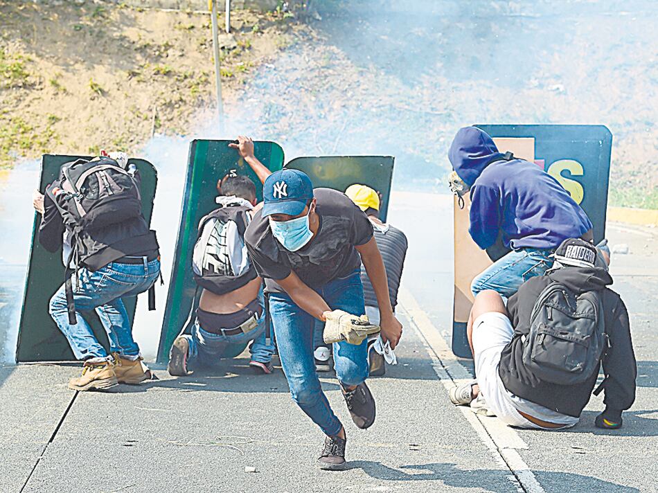 Activistas opositores se escudan en carteles viales arrancados.