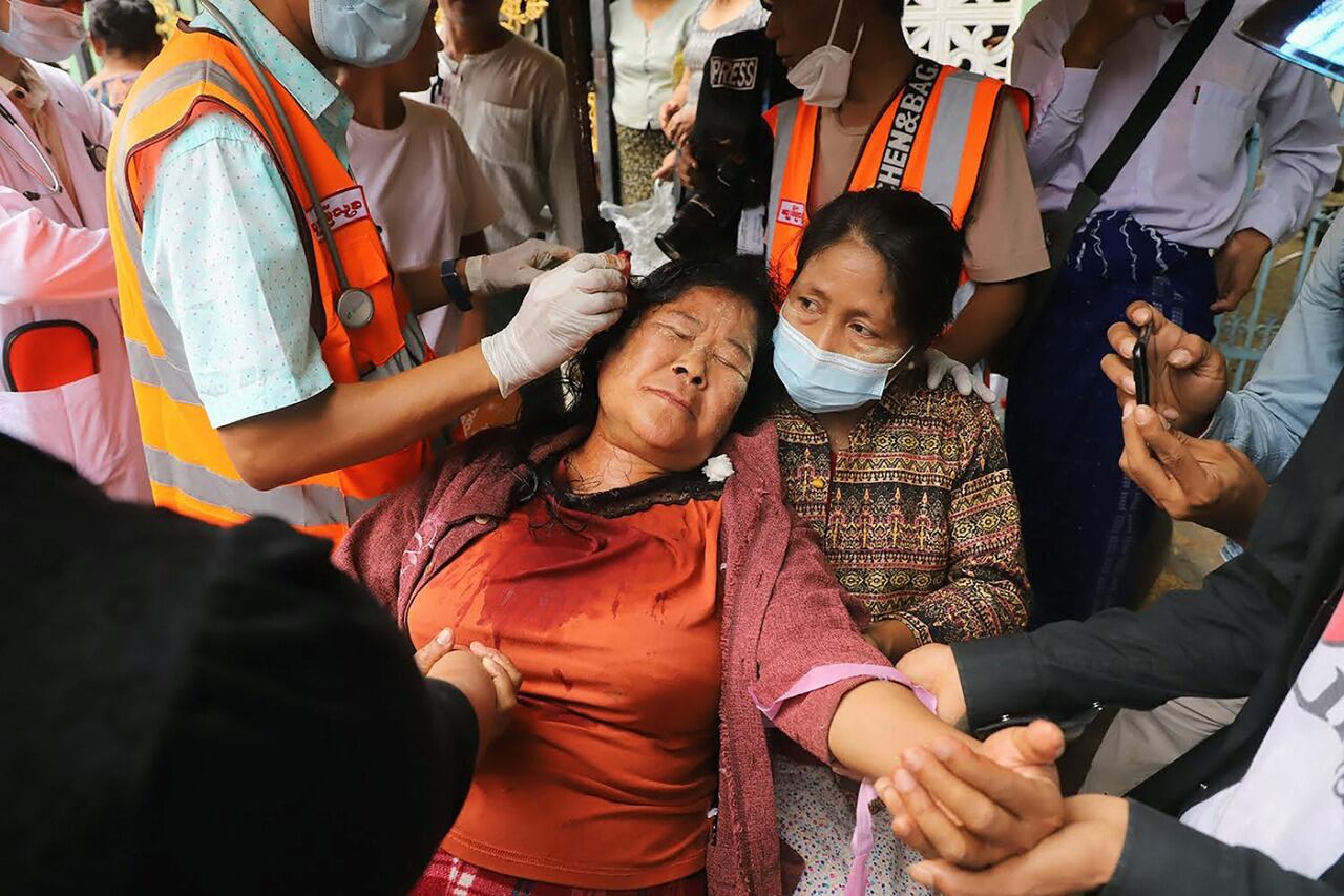 Tratan a una mujer herida durante una protesta en Mandalay.