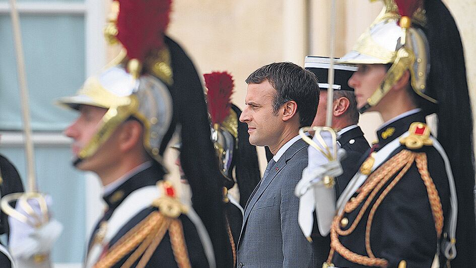 Macron rodeado de guardias ceremoniales durante un acto en el Elíseo.