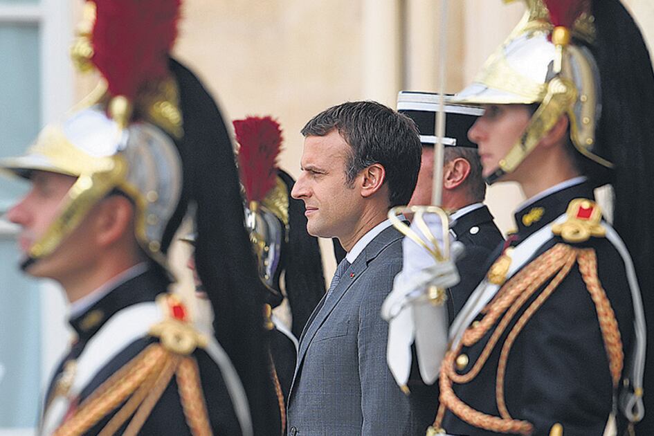 Macron rodeado de guardias ceremoniales durante un acto en el Elíseo.