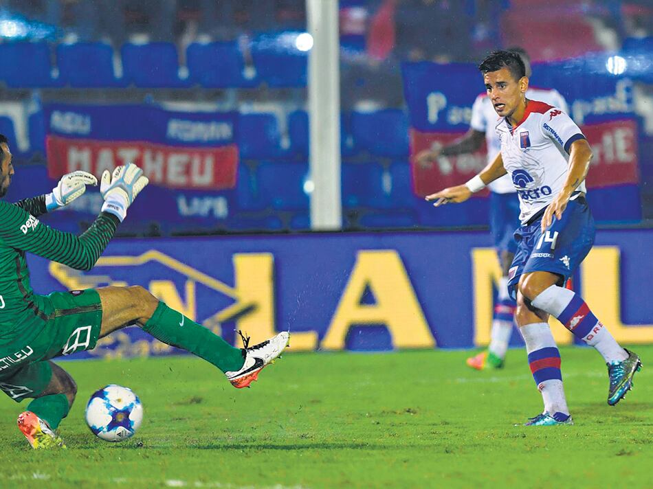 Agustín Cardozo define ante la salida de Torrico, para marcar el primero de los cuatro goles de su equipo.