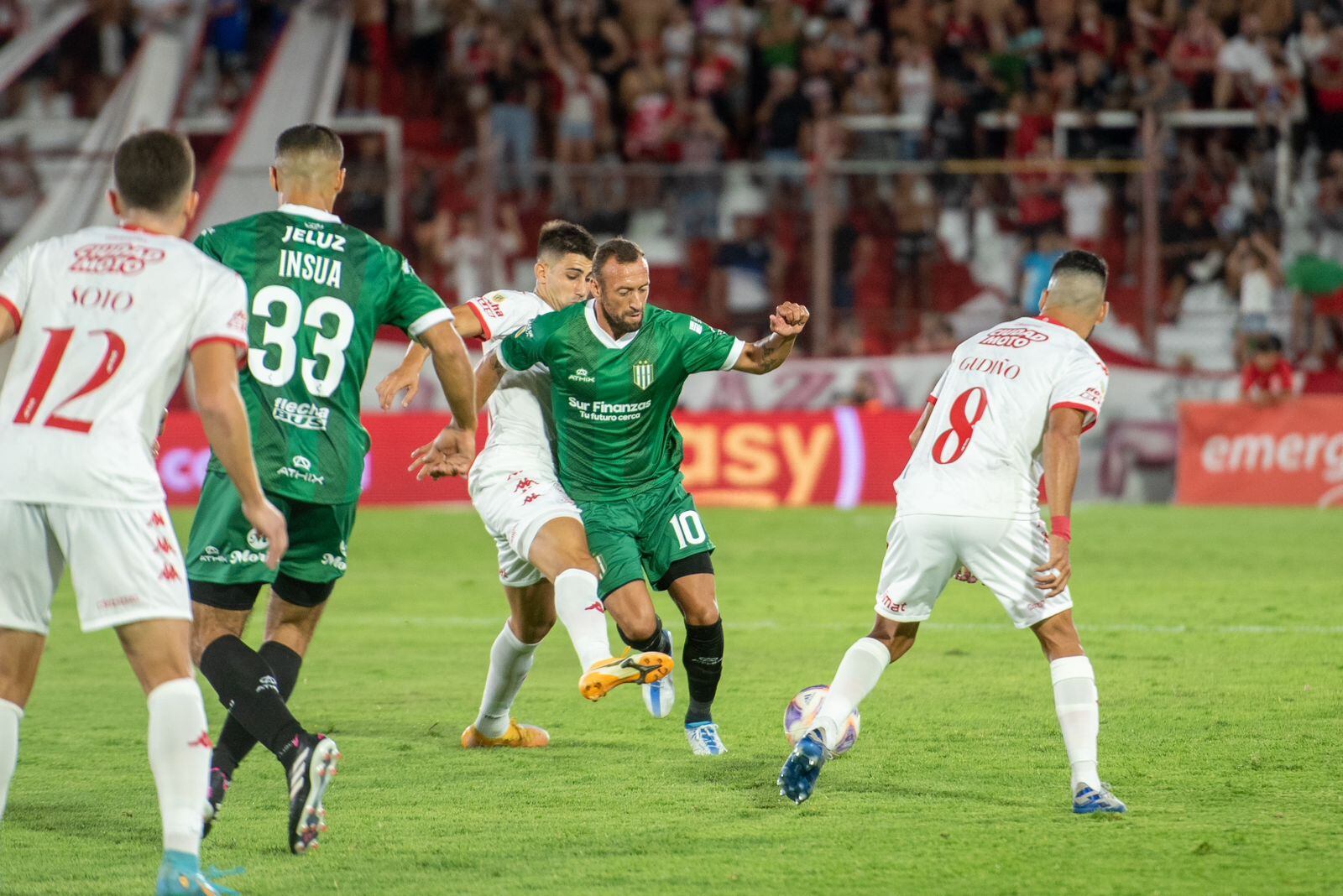 Alemán intenta pasar entre dos jugadores del Globo, que superó al Taladro