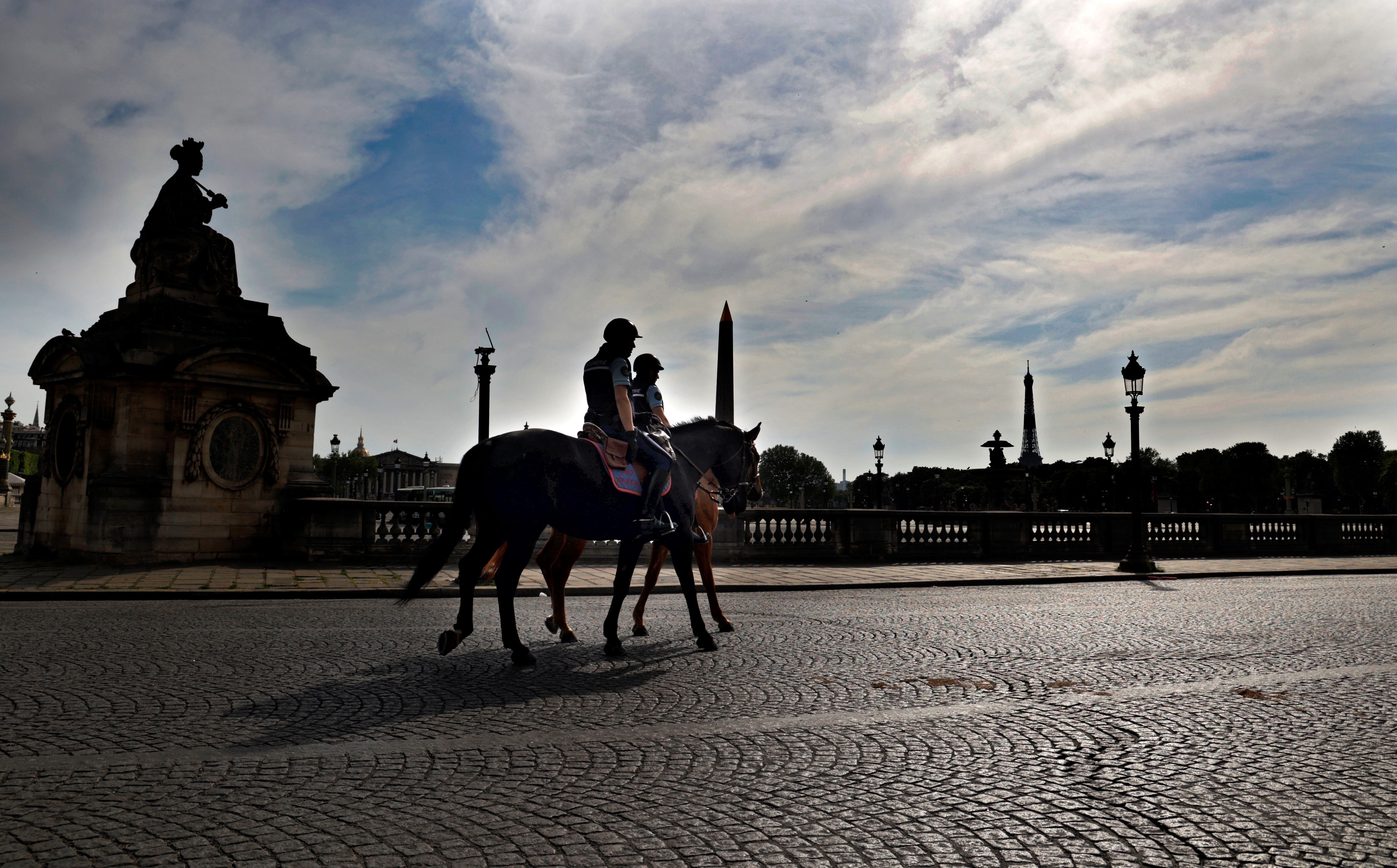 Dos policías montados patrullan las calles desiertas de París en plena cuarentena por el coronavirus. 