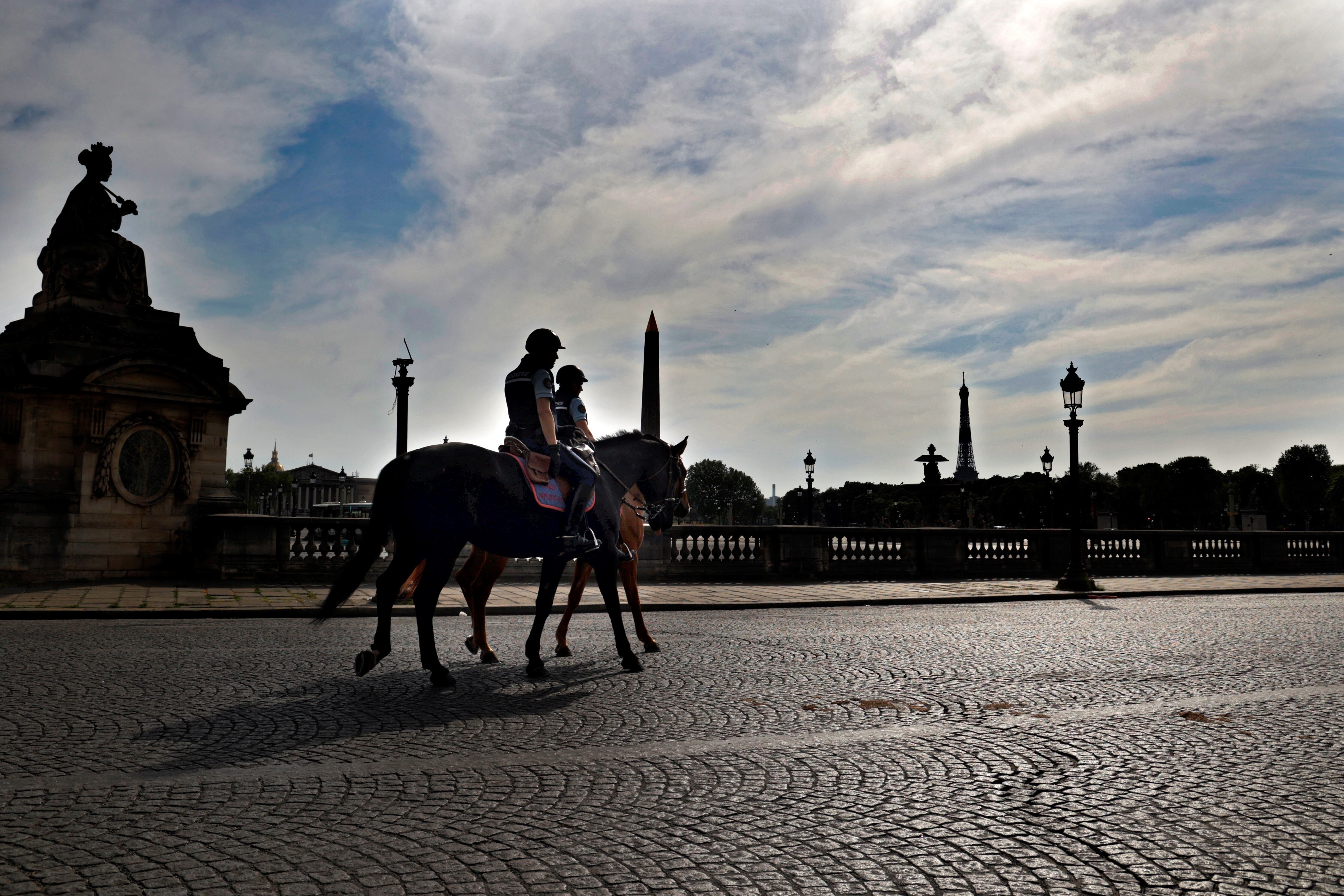 Dos policías montados patrullan las calles desiertas de París en plena cuarentena por el coronavirus.