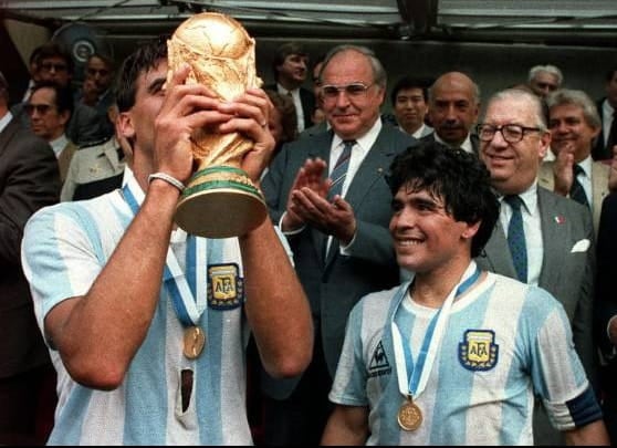 El exministro de Alfonsín, Conrado Storani, con lentes gruesos atrás de Maradona. 