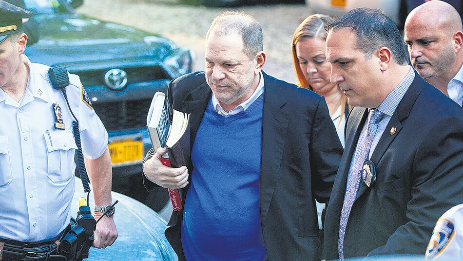 El ex productor, acompañado por su abogado, entra en la comisaría de Manhattan para entregarse.