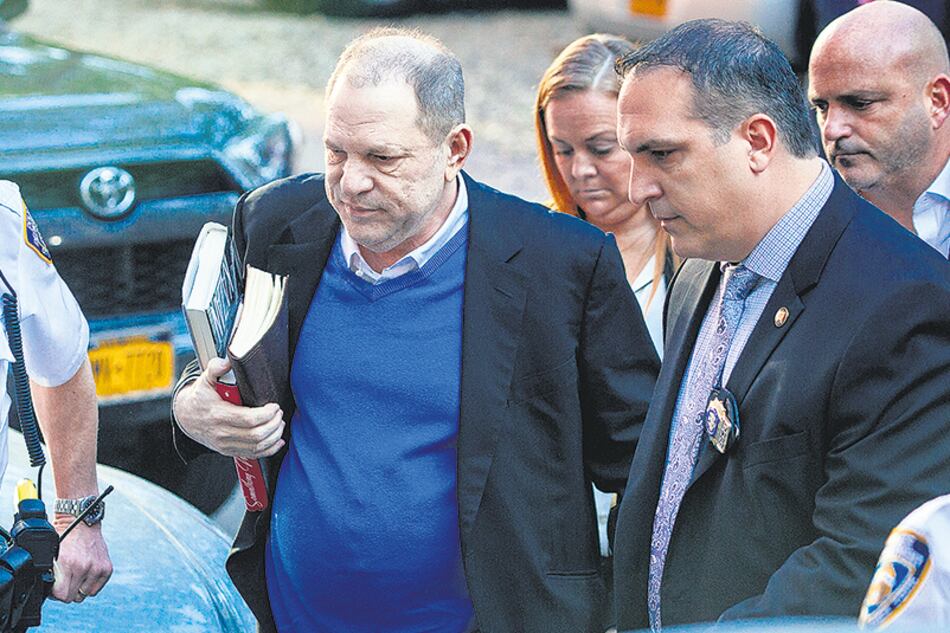 El ex productor, acompañado por su abogado, entra en la comisaría de Manhattan para entregarse.