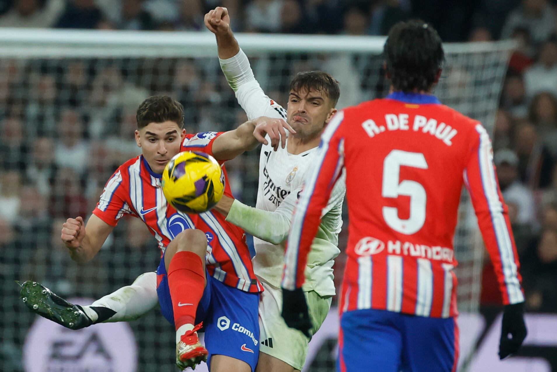Julián Álvarez en lucha por la pelota, De Paúl sigue la jugada.